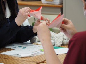 英語で折り紙の折り方を伝えています。
