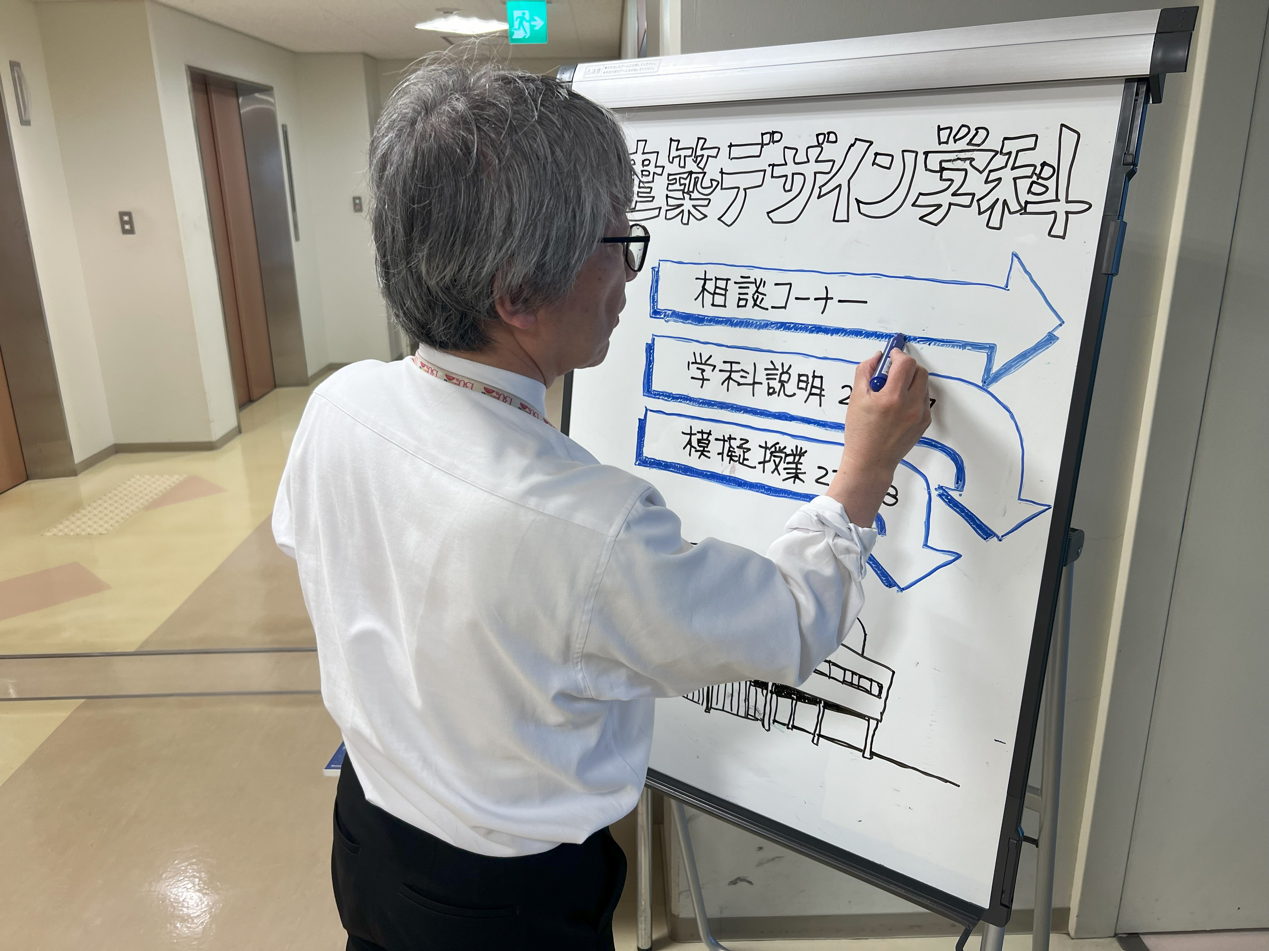 学科案内看板を製作する山田学科長