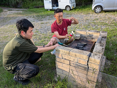 井上さんと田岡さんがバーベキューの火起こし